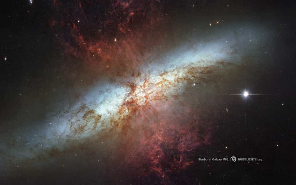 La galaxie M82 est cinq fois plus lumineuse que la Voie lactée car elle est le lieu d’une flambée de formation de nouvelles étoiles, très probablement parce qu’elle est passée au voisinage de la galaxie M81, il y a quelques centaines de millions d’années.  Cette image prise par Hubble combine des photographies dans le visible et l’infrarouge avec six filtres dans des bandes déterminées, ce qui permet de voir des volutes de gaz et de poussières (en rouge) qui s’écartent de M82. © Nasa, Esa, The Hubble Heritage Team (STScI/AURA)