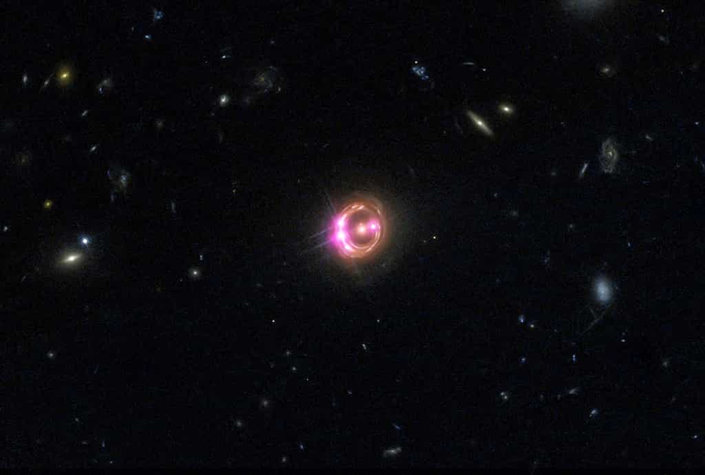 L'anneau d'Einstein, que l'on voit ici sur cette image composite réalisée à partir d'observations réalisées dans le visible avec Hubble et dans le domaine des rayons X avec Chandra, montre des images démultipliées du quasar RX J1131-1231. Il s'agit d'un effet de lentille gravitationnelle provoqué par une galaxie elliptique massive s'étant interposée entre ce quasar et nous. © Rayons X : Nasa, CXC, université du Michigan, R. C. Reis et al. ; optique : Nasa, STScI