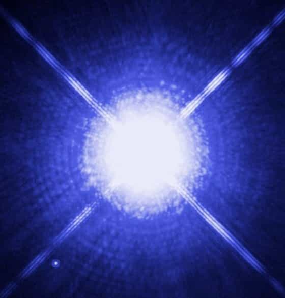 L'étoile Sirius A, photographiée dans le visible par Hubble, n'est qu'à 8,6 années-lumière de la Terre. Elle fait en réalité partie d'un système binaire, et sa compagne, Sirius B, est visible sous la forme d'un petit point peu lumineux en bas à gauche. Sirius B est une naine blanche dont le diamètre est d'environ 12.000 km. Les naines blanches peuvent servir de laboratoire naturel pour tester des théories en physique des particules. © Nasa, Esa