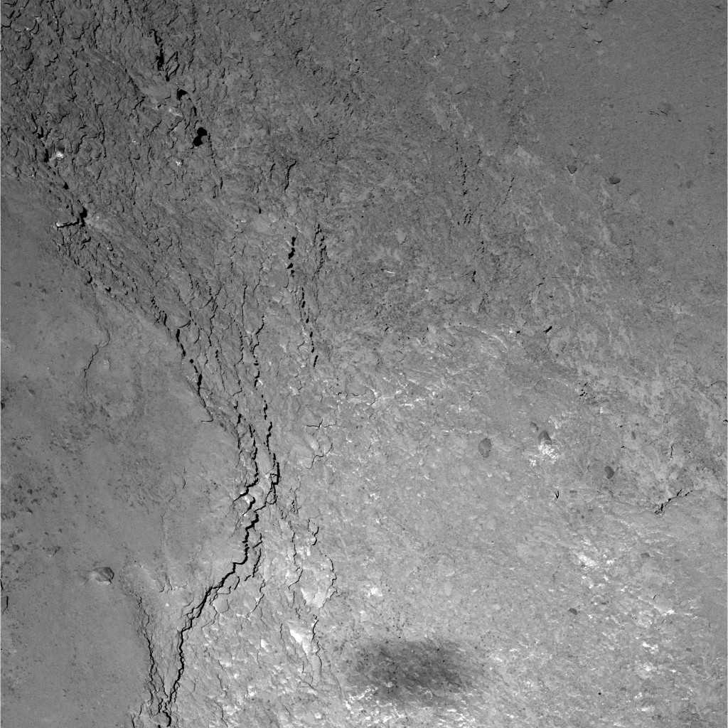 Dans cette aire de 228 x 228 m couverte par la caméra à angle étroit, petit champ (Nac) de l’instrument Osiris à bord de Rosetta, on distingue de magnifiques détails de la surface de la comète 67P/Churyumov-Gerasimenko, capturés lors du survol du 14 février, à 6 km d’altitude. En bas de l’image, on aperçoit l’ombre grossière de Rosetta qui s’étend sur quelque 20 x 50 m. La résolution est de 11 cm par pixel. Téléchargez l’image en haute résolution ici. © Esa, Rosetta, MPS for Osiris Team, MPS, UPD, Lam, IAA, SSO, Inta, UPM, DASP, Ida