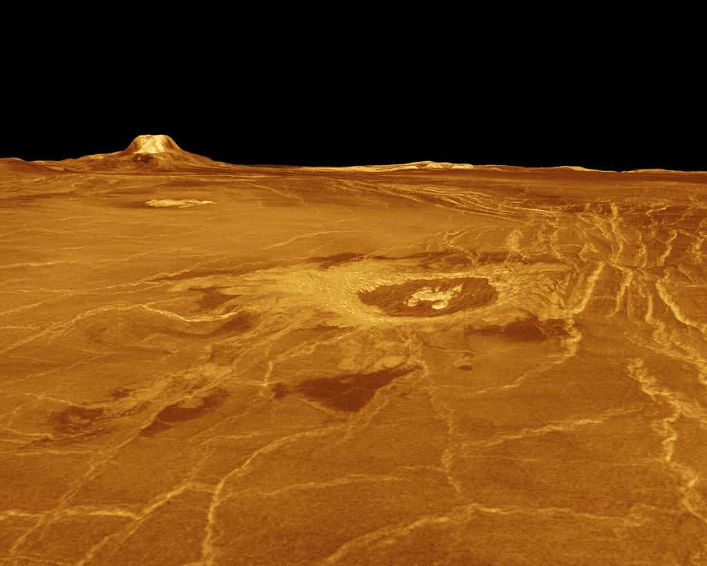 Cette image a été obtenue à partir des données radar de la sonde Magellan qui a observé et cartographier la surface de Vénus durant 4 ans (d’août 1990 à octobre 1994). Elle montre Eistla Regio avec à l’horizon Gula Mons. Les observations de Magellan ont permis d’établir que la surface de Vénus est globalement jeune, avec un âge moyen de quelques centaines de millions d’années tout au plus. En effet, on n’y observe que peu de cratères d’impact. On constate aussi que la surface est caractérisée par un volcanisme important, puisque toute la surface de Vénus est constituée de volcans, de coulées, de caldeiras et de dômes. Mais au cours des 4 années qu’ont duré les observations au radar de Magellan, ni panaches de cendres ni modifications notables de la surface de Vénus n’ont été détectés. Il y avait donc un débat sur la réalité d’une activité actuelle ou récente du volcanisme sur Vénus. © Nasa