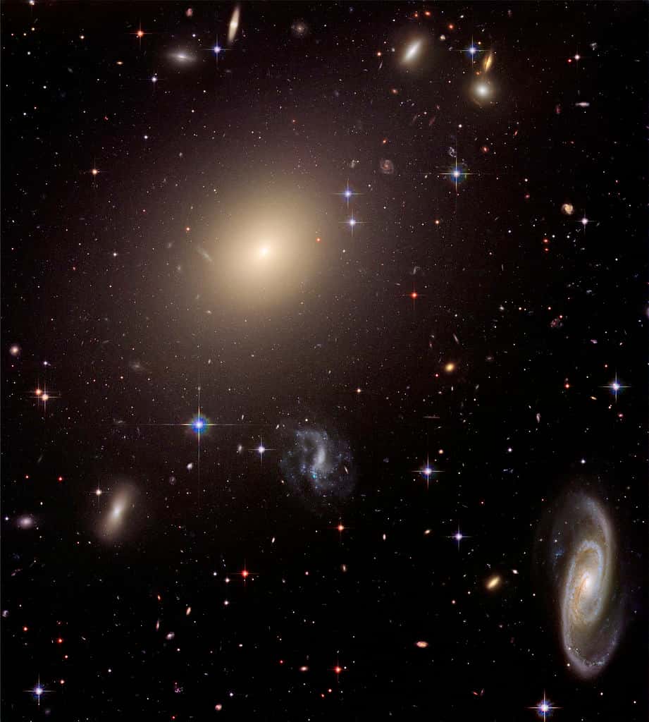 Abell S0470 est un amas de galaxies situé dans la constellation du Centaure, à environ 465 millions d'années-lumière (143 Mpc) de la Voie lactée. Il est dominé par ESO 325-G004, une galaxie elliptique géante dont la masse provoque un effet de lentille gravitationnelle sur les objets situés au loin à l'arrière-plan. ESO 325-G004 est un exemple typique de <em>Brightest Cluster Galaxy</em>. © Nasa, Esa