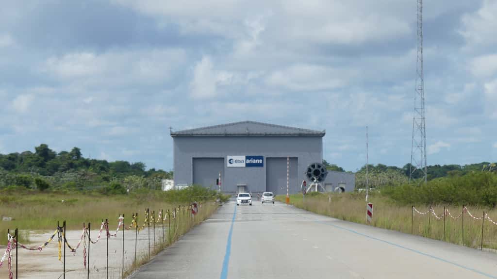 Vu depuis le pas de tir, au bout de la route : le Bâtiment d'assemblage lanceur (BAL). L'assemblage se faisant à l'horizontale, le bâtiment est beaucoup moins haut que les infrastructures d'Ariane 5. © Daniel Chrétien, Futura