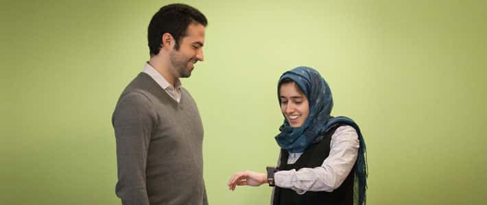Mohammad Ghassemi (à gauche) et Tuka Alhanai, portant la montre, testent le dispositif sur lequel ils travaillent au CSAIL, un laboratoire du MIT. © CSAIL
