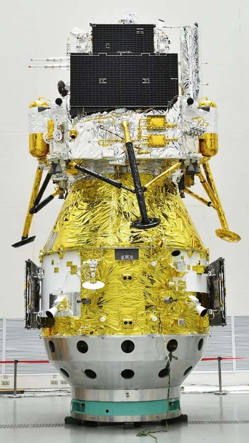 La sonde Chang'e 6 sur son adaptateur avec le bout du lanceur Long March 5. Dans la moitié basse (en doré) se trouve le module de service, qui restera en orbite puis reviendra vers la Terre. Il porte au-dessus l'atterrisseur qui contient un module de descente (avec les jambes) et un module de remontée (en haut) qui décollera de la Lune avec les échantillons, et les transmettra au module de service avant le retour sur Terre. Sur le flanc gauche de l'atterrisseur, on distingue un petit rover chinois ; sur le flanc droit, se tient en position inclinée le détecteur de radon français Dorn. © CNSA, Casc