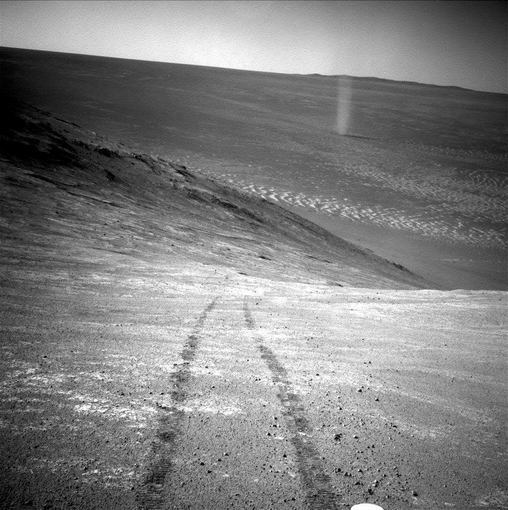 « Démon de poussière » à l’intérieur du grand cratère d’impact Endeavour (22 km de diamètre) photographié par la NavCam d’Opportunity lors 4.332<sup>e</sup> jour sur Mars. Le rover se roule sur le flanc sud de la vallée de Marathon qui coupe d’est en ouest le bord du cratère. Derrière le tourbillon, apparaît la crête du bord opposé. © Nasa, JPL-Caltech