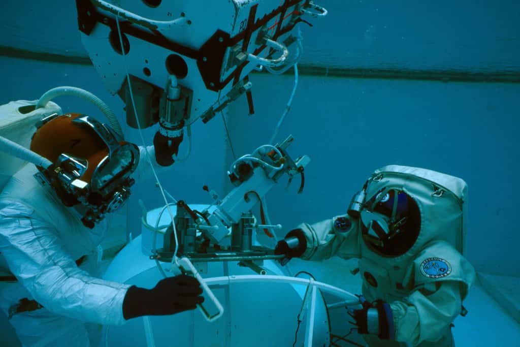Un essai en piscine du scaphandre de test Gandolfi, en 1988. Jean-François Clervoy, à droite, reproduit un travail dans l’espace. Il baigne dans l’eau, en tenue de plongée, et respire dans un détendeur. Cette situation simule mieux les effets de l’apesanteur sur la réorganisation sensorimotrice des mouvements. En revanche, pour l’entraînement à une EVA et la répétition des gestes, un scaphandre semblable à celui utilisé dans l’espace est préférable. © Alain Tocco 