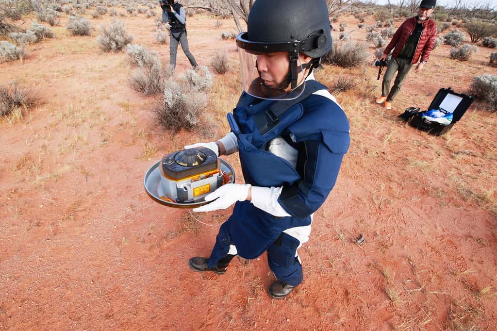 Il n'a pas trébuché ! L'ingénieur de la Jaxa tenait dans ses mains la capsule renfermant les échantillons d'Hayabusa-2, peu après que la capsule a été retrouvée en Australie. © Jaxa