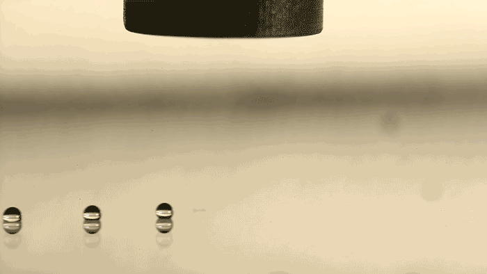 Des gouttes de miel, dont la viscosité est très élevée, sont détachées de la buse par des ondes acoustiques et déposées sur une plaque en verre. © Daniele Foresti, Jennifer A. Lewis, <em>Harvard University</em>