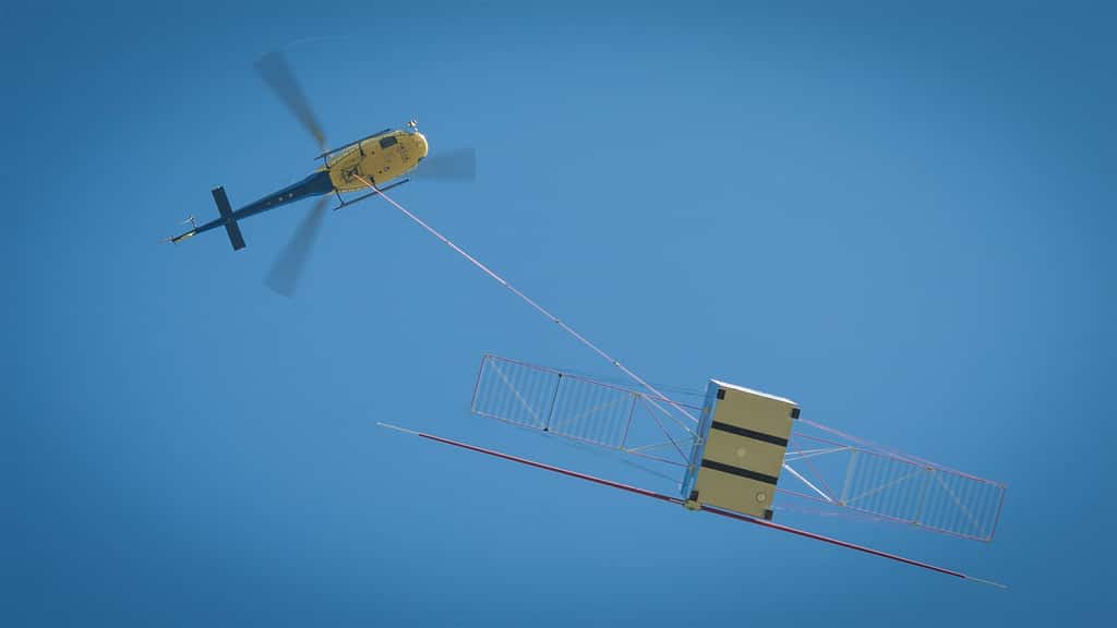 Essai du radar Rime installé sur la maquette de la sonde Juice. L'ensemble était suspendu à une corde en polyéthylène d’environ 120 mètres en dessous d’un hélicoptère évoluant à 320 mètres au-dessus du sol. © Airbus