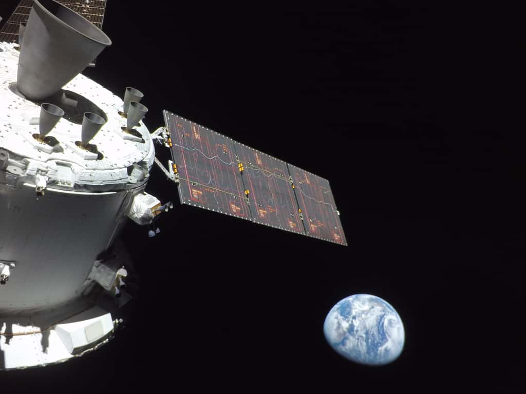Le vaisseau Orion vu depuis une caméra embarquée au bout d'un panneau solaire, avec la Terre en arrière-plan. © Nasa