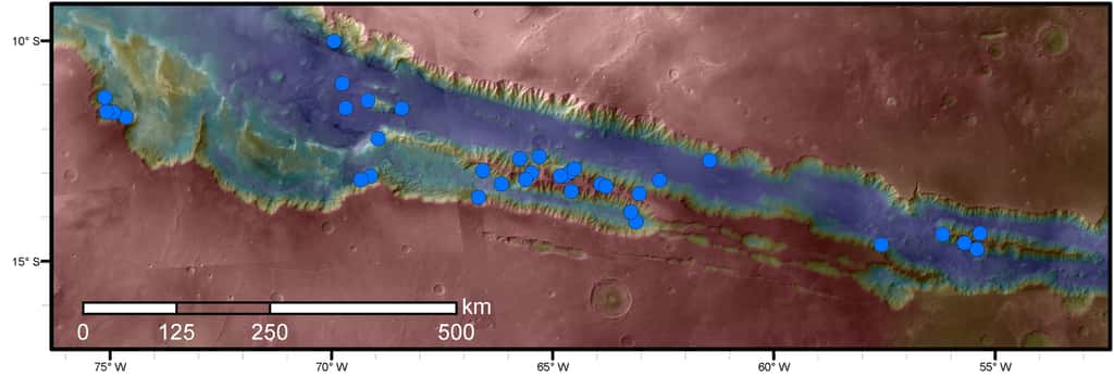 Les différents sites étudiés par l’équipe sont marqués par des disques bleus. Ils figurent tous dans le réseau de canyons de <em>Valles Marineris</em>. En bleu : altitudes les plus basses ; en rouge : les plus hautes. © Nasa, JPL-Caltech, <em>University of Arizona</em>