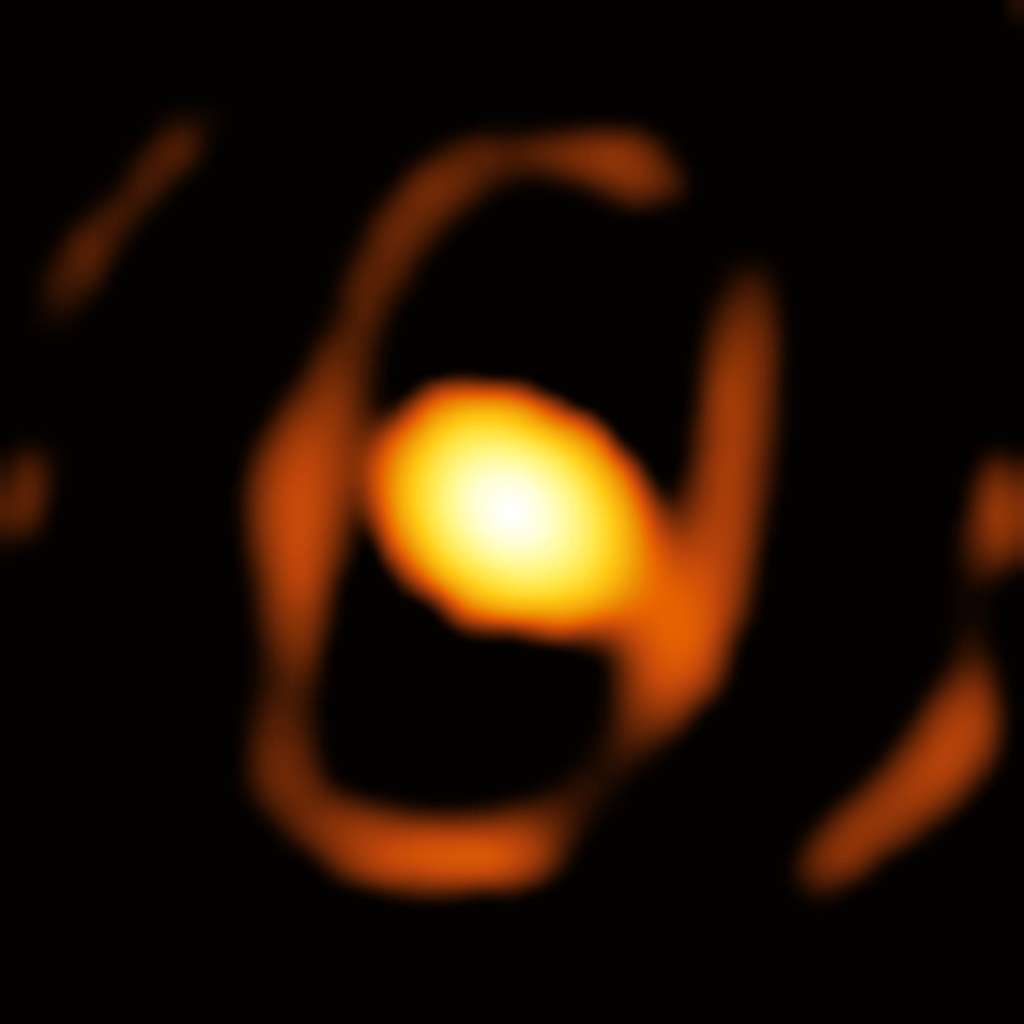 Voici une image de l'étoile WOH G64, prise par l'instrument Gravity du <em>Very Large Telescope Interferometer</em> (VLTI) de l'Observatoire européen austral (ESO). Il s'agit de la première image en gros plan d'une étoile située en dehors de notre Galaxie, la Voie lactée. L'étoile se trouve dans le Grand Nuage de Magellan, à plus de 160 000 années-lumière. L'ovale brillant au centre de l'image (environ 21 milliards de kilomètres de large sur 31 de long) est un cocon de poussière qui entoure l'étoile. L'anneau elliptique plus faible qui l'entoure (environ 46 milliards de kilomètres de large sur 75 de long) pourrait être le bord interne d'un tore poussiéreux, mais d'autres observations sont nécessaires pour confirmer cette caractéristique. © ESO, K. Ohnaka et <em>al.</em>