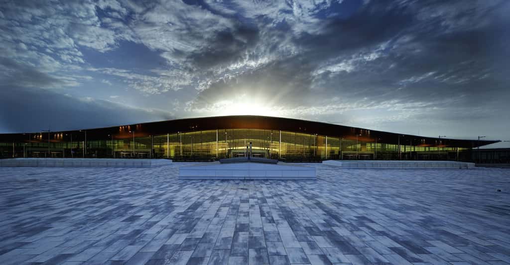 Le terminal 1 de l’aéroport de Barcelone (Espagne) a été inauguré en 2010. Il est l’œuvre — tout comme le terminal 2 — de l’architecte espagnol Ricardo Bofill. Sa forme générale ondulée rappelle tout simplement celle d’un avion. Et grâce à des murs totalement en verre, il est littéralement inondé de lumière naturelle.
Imaginé dans un souci de durabilité, le toit en aluminium du bâtiment est équipé d’une centaine de panneaux solaires qui permettent de chauffer 70&nbsp;% de l’eau utilisée dans ce terminal. © RBTA Marketing Team, Wikimedia, CC0