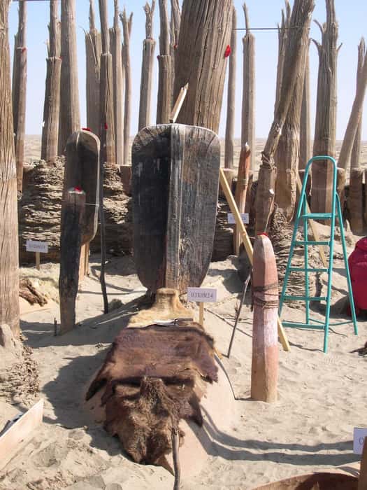 Cercueil en forme de bateau recouvert d'une peau de bête et surmonté d'une rame, à Xiaohe. © Wenying Li, <em>Xinjiang Institute of Cultural Relics and Archaeology</em>