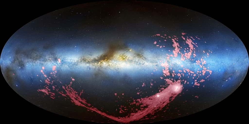 On distingue en fausses couleurs la voûte céleste avec la Voie lactée dans le visible, et le courant magellanique (en rose dans l'hémisphère galactique sud). Son image provient d'observations faites dans le domaine radio grâce à la raie à 21 cm de l'hydrogène atomique neutre. En bas à droite, sous forme de deux taches blanches, on voit les deux Nuages de Magellan. © David L. Nidever <em>et al.</em>, NRAO-AUI-NSF-Mellinger