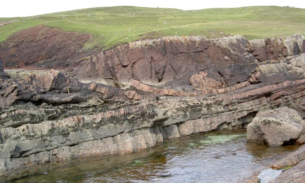 Dépôts sédimentaires de grès rouge issus de l’impact d’une météorite de 1 km de large il y a 1,2 milliard d’années, dans le nord-ouest de l’Écosse. © Ken Amor, <em>University of Oxford</em>