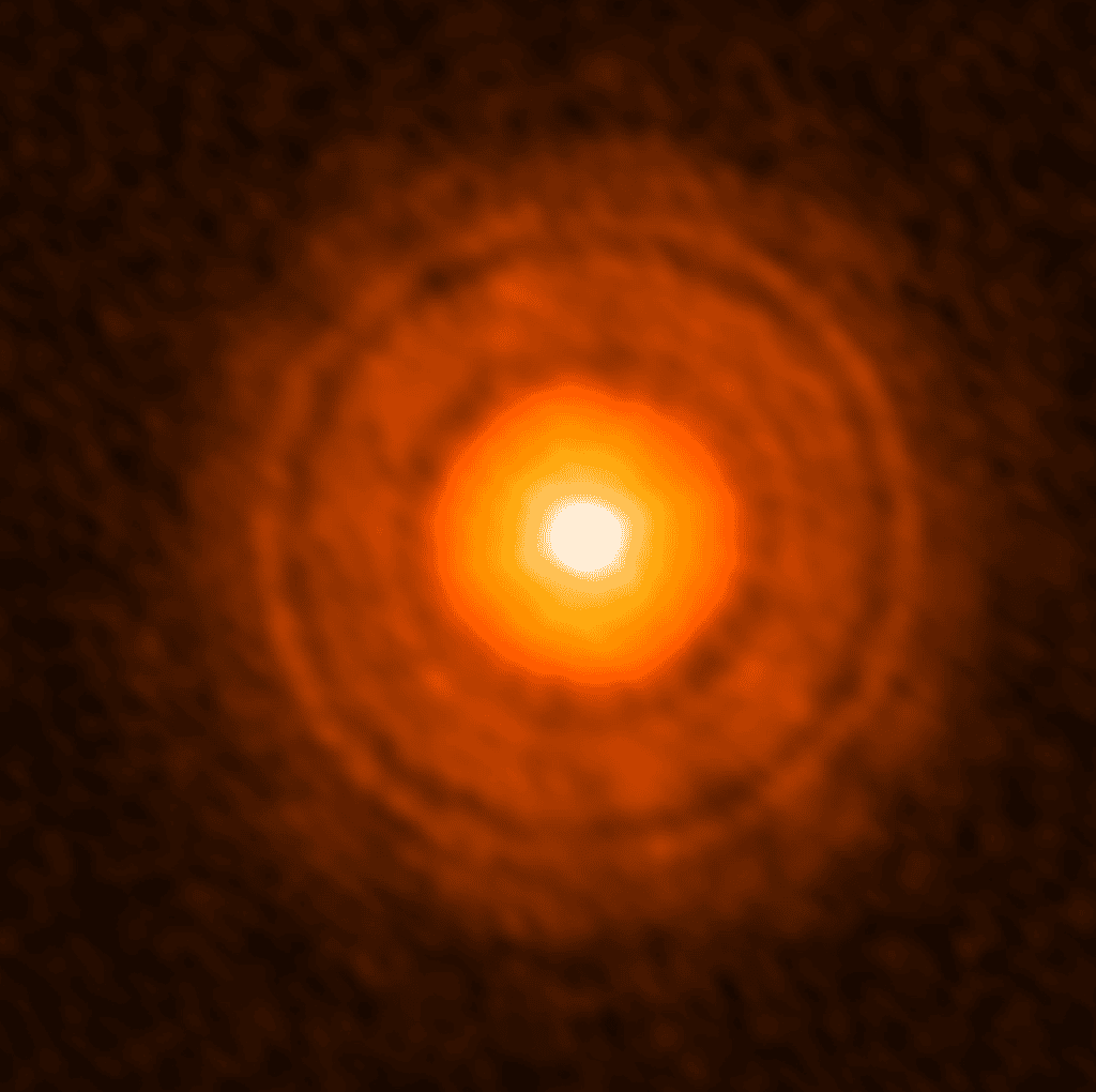 Sur cette image en fausses couleurs prise par Alma, le disque protoplanétaire autour de l'étoile TW Hydrae est bien visible ainsi que des anneaux moins lumineux. Il s'agit de régions moins denses en gaz et poussières, dépourvues de particules de grandes tailles et qui seraient la manifestation de la présence d'exoplanètes. © Alma (ESO/NAOJ/NRAO), Tsukagosh<em>i et al. </em>