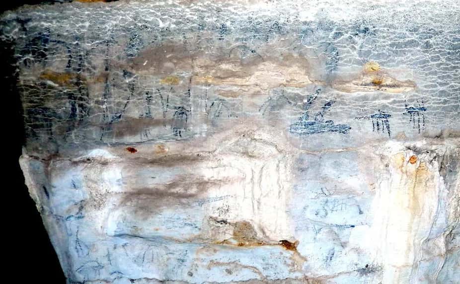 Photographie de l'un des murs de la grotte d'Andriamamelo, sur laquelle on observe les figures peintes à l'encre noire. © David Burney, <em>The Conversation</em>