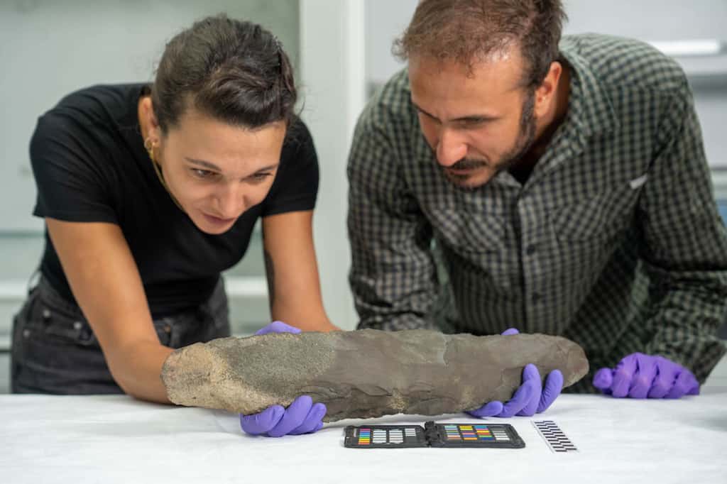 Les archéologues Giulia Edmond et Omer Aksoy observent la hache préhistorique déterrée en Arabie saoudite, mesurant 51 centimètres. © The Royal Commission for AlUla