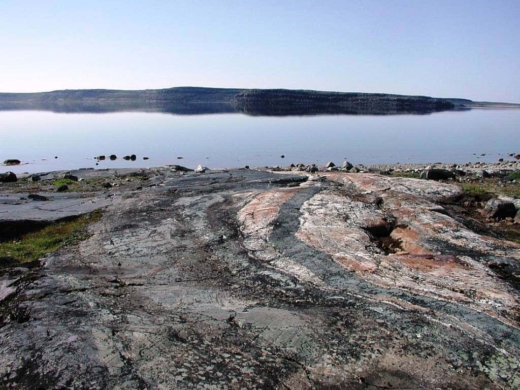 Un affleurement de roches métamorphiques à Porpoise Cove, de la ceinture supracrustale du Nuvvuagittuq (Canada). Certaines de ces roches ont un rapport Sm/Nd indiquant un âge  pouvant être de plus de 4 milliards d’années mais il n'est pas clair que ce soit l'âge réel de la formation de ces roches. Elles feraient de toute façon partie des plus anciennes roches sur Terre. © <em>Nasa Astrobiology Institute</em> 