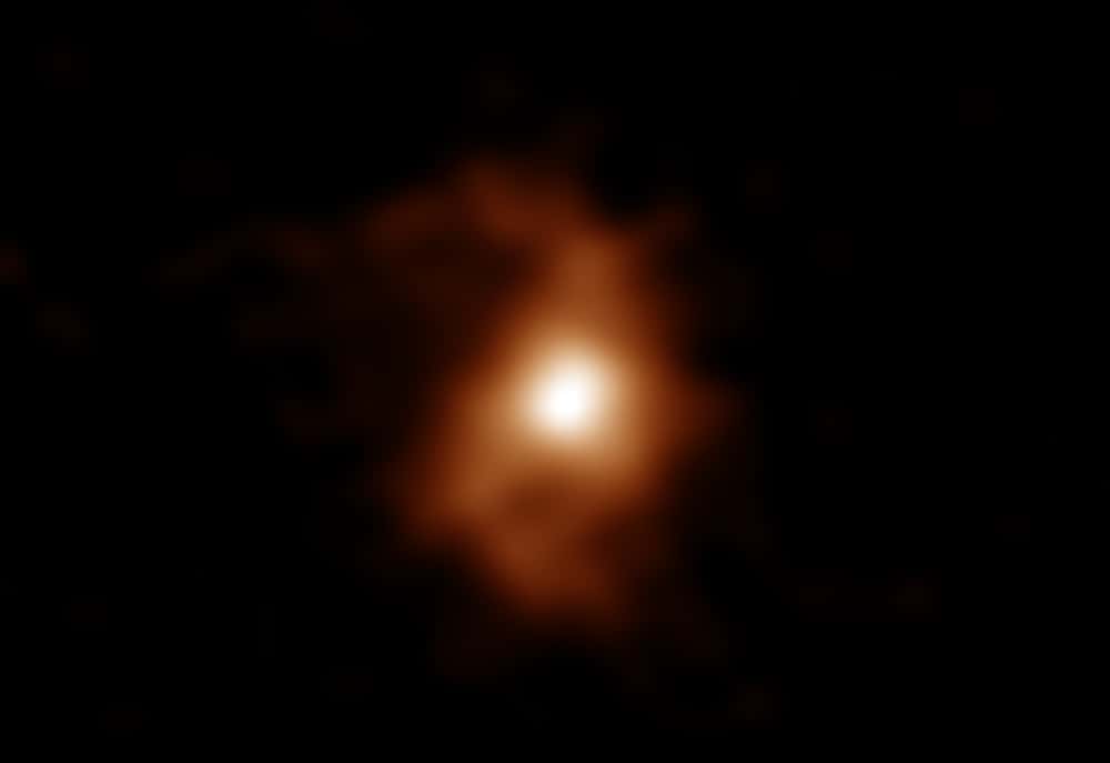 Voici en fausses couleurs une image d'Alma de la galaxie BRI 1335-0417 il y a 12,4 milliards d'années. Alma a détecté les émissions d'ions carbone dans la galaxie. Les bras en spirale sont visibles des deux côtés de la zone compacte et lumineuse au centre de la galaxie. Le décalage vers le rouge de cet objet est z = 4,41. C'est en utilisant les paramètres cosmologiques mesurés avec le satellite Planck (H<sub>0</sub> = 67,3 km / s / Mpc, Ω<sub>m</sub> = 0,315, Λ = 0,685: Résultats Planck 2013) que nous pouvons calculer sa distance. © Alma (ESO/NAOJ/NRAO), T. Tsukui & S. Iguchi