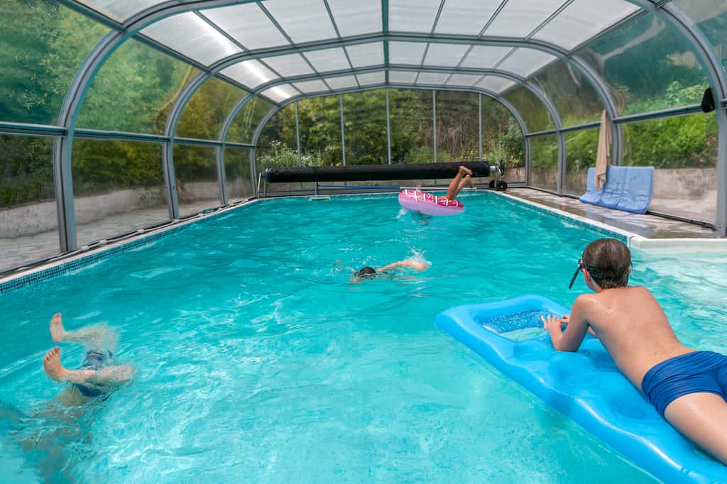 L'abri de piscine fait partie des dispositifs de sécurité préconisés par la loi. Qu'il soit haut ou bas, il permet aussi de gagner quelques degrés de température en plus. © JPC-Prod, Adobe Stock