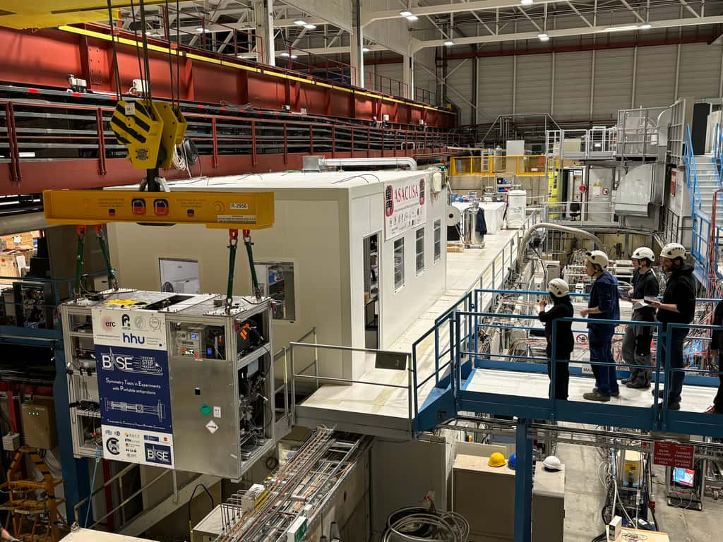 Le système de piège transportable Base-Step, déplacé à l’aide d’une grue dans le hall du Décélérateur d’antiprotons, avant d’être chargé sur un camion. L’équipe a surveillé tous les paramètres pendant le transport. © Cern