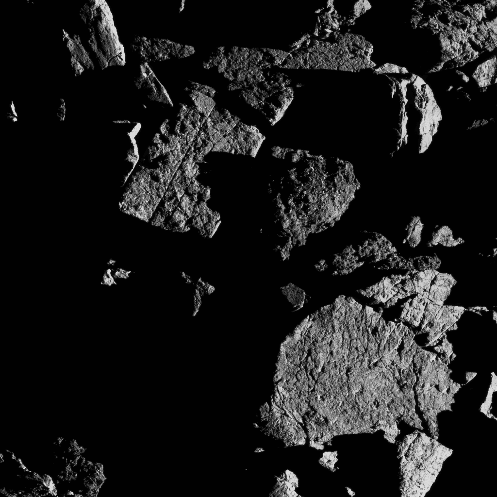 Groupe de gros rochers situés juste au nord de la région équatoriale de Bennu. Le rocher en bas à droite montre des signes d'exfoliation, où la fracturation thermique a probablement provoqué l'écaillage de petites couches minces de la surface du rocher. © Nasa, Goddard University of Arizona