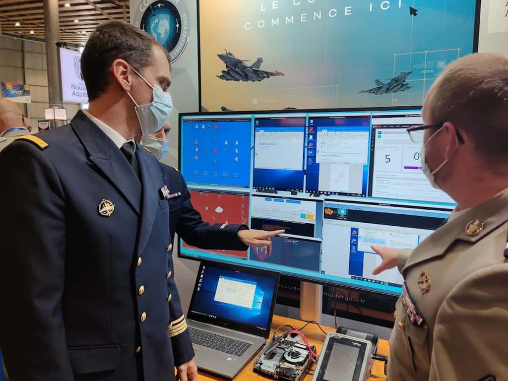 Sur le salon du FIC à Lille, l’adjudant Sébastien présente au capitaine de corvette Xavier le Trident, un caisson d’entraînement à la cyberdéfense d’un réseau équivalent à celui d’une PME. © Futura