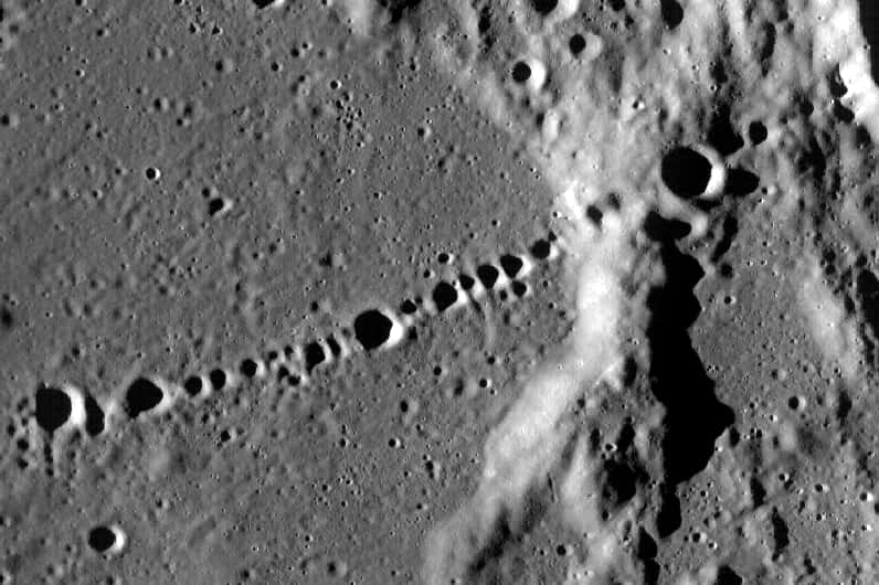 La sonde LRO a pris cette image montrant une chaîne de cratères lunaires appelée<em> Catena Day</em>. Il semble qu'elle soit le produit d'une série de petits corps célestes similaires à ceux nés de la fragmentation de la comète Shoemaker-Levy 9. © Nasa