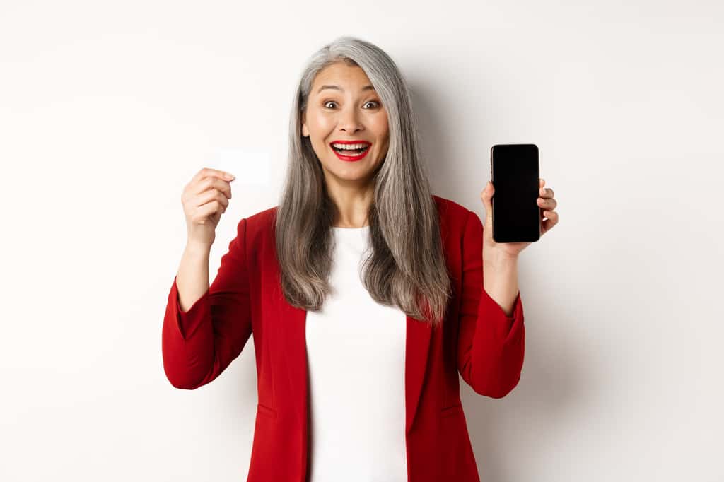 Une femme senior utilise son smartphone en toute simplicité : avec les forfaits mobiles adaptés