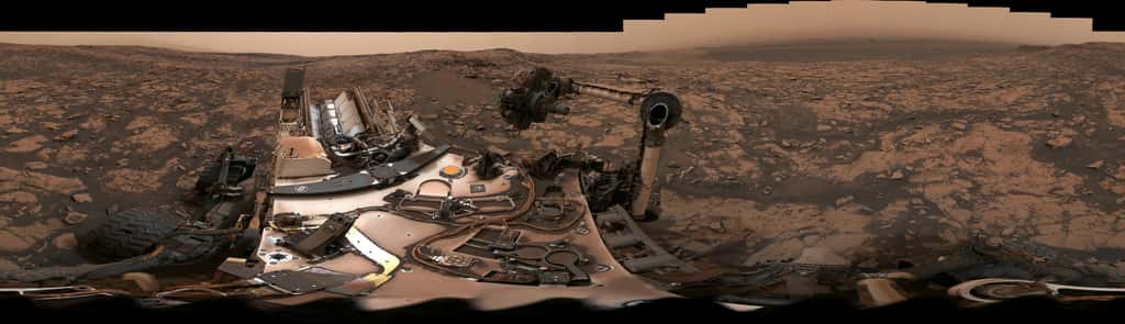 Vue panoramique à 360° prise par Curiosity le 9 août 2018. La tempête globale qui a duré plus de deux mois terrestres a couvert le rover de poussière. À ses pieds, devant le damier, on aperçoit le forage « Stoer ». © Nasa, JPL-Caltech, MSSS