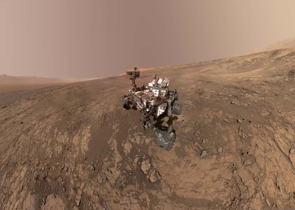 Curiosity sur le site Vera Rubin, le 23 janvier 2018 (sol 1943). Des dizaines d'images assemblées composent ce nouveau selfie. Juste derrière le rover, le site qu'il va bientôt explorer. Tout au fond : le sommet du mont Sharp. Téléchargez l'image en haute résolution <a target="_blank" href="https://photojournal.jpl.nasa.gov/jpeg/PIA22207.jpg">ici</a>. © Nasa, JPL-Caltech, MSSS