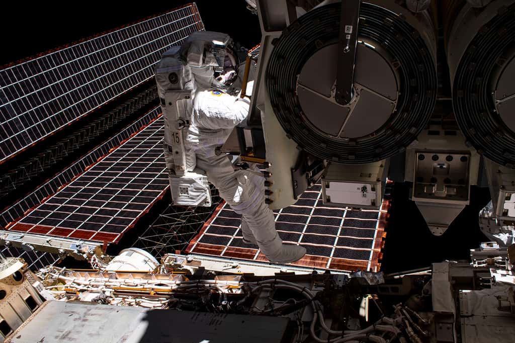 Shane Kimbrough lors de la sortie extravéhiculaire le 16 juin 2021 qui s'affaire autour du premier iROSA dont ont peut voir qu'il est roulé sur lui-même en deux cylindres repliés l’un sur l’autre. Et non, l'astronaute américain ne « marche » pas sur les panneaux solaires actuellement en service. © Nasa