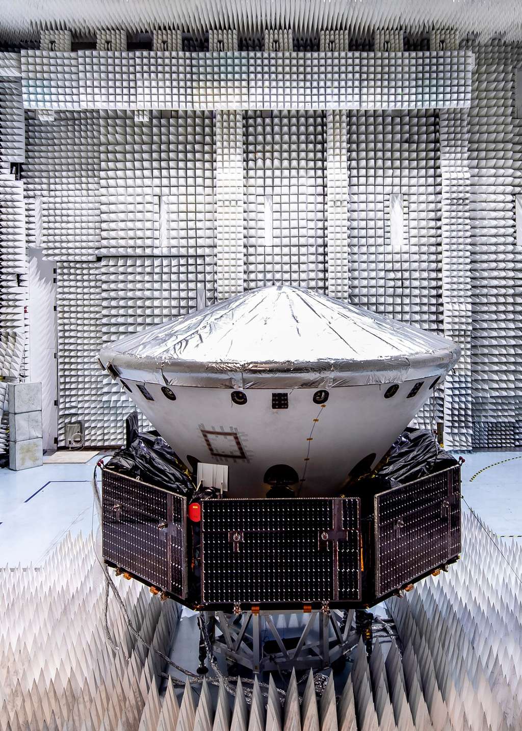 La sonde ExoMars 2020, lors d'essais dans une des chambres anéchoïques de l'usine cannoise de Thales Alenia Space. ExoMars 2020 est ici vu dans sa configuration de vol avec le module de transfert (le carrier, reconnaissable à ses panneaux solaires), le bouclier thermique (avec les cônes avant et arrière) à l'intérieur duquel se trouve la plateforme d'atterrissage Kazachok qui supporte le rover Rosalind Franklin (absent lors de cet essai). © Thales Alenia Space, Alizée Palomba