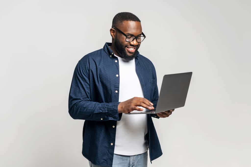 Homme tenant un PC portable © Shutterstock