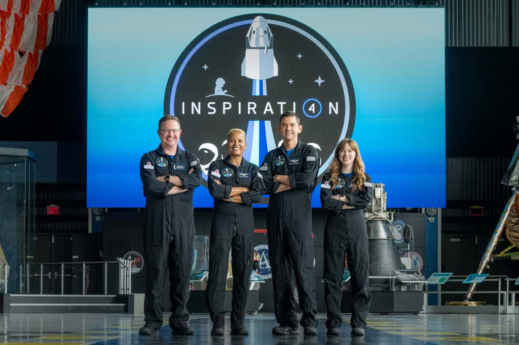 Les membres de la première mission mondiale entièrement civile dans l'espace pose devant l'écusson d'Inspiration4. © Inspiration4, John Kraus