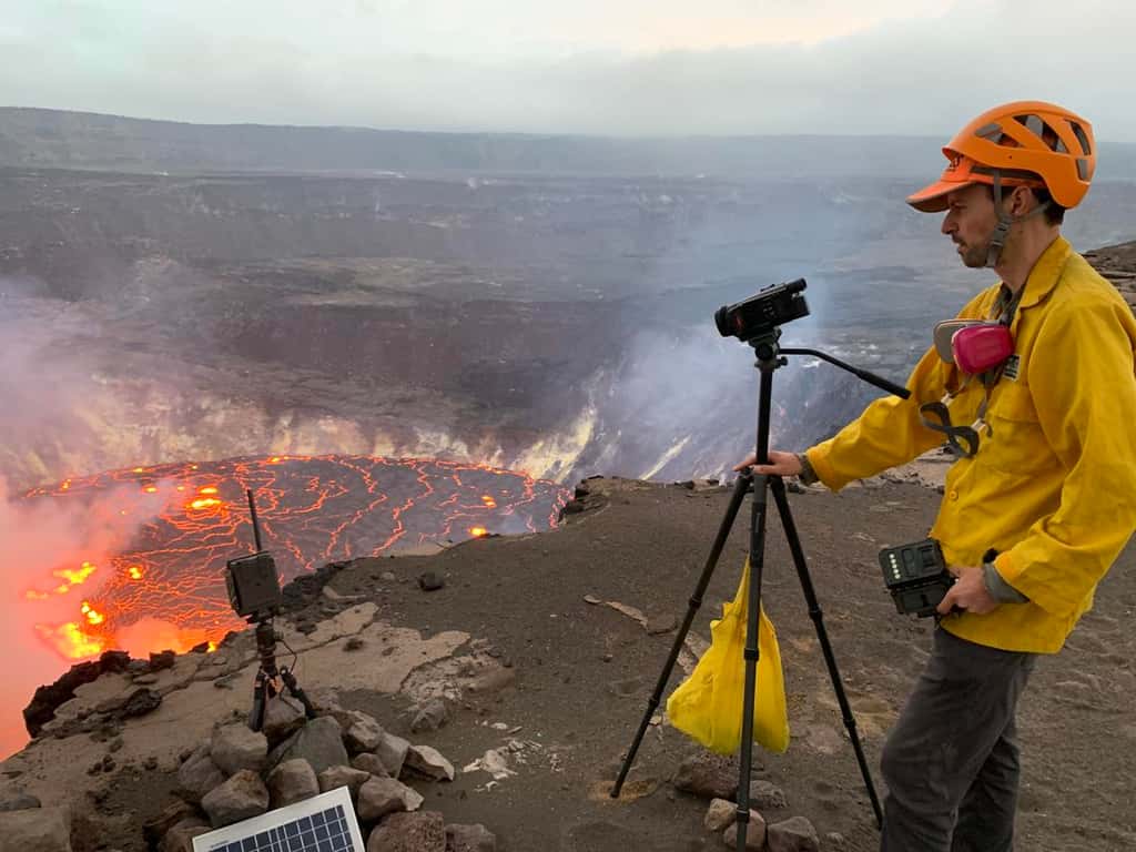Un géologue de l'USGS <em>Hawaiian Volcano Observatory</em> enregistre une vidéo de l'éruption qui a commencé dans le cratère Halema'uma'u, au sommet du Kīlauea. Les scientifiques continuent de surveiller l'éruption et les dangers dans une zone du parc national des volcans d'Hawai'i qui reste fermée au public pour des raisons de sécurité. © Photo de l'USGS prise depuis la rive sud de Halema'uma'u par D. Downs
