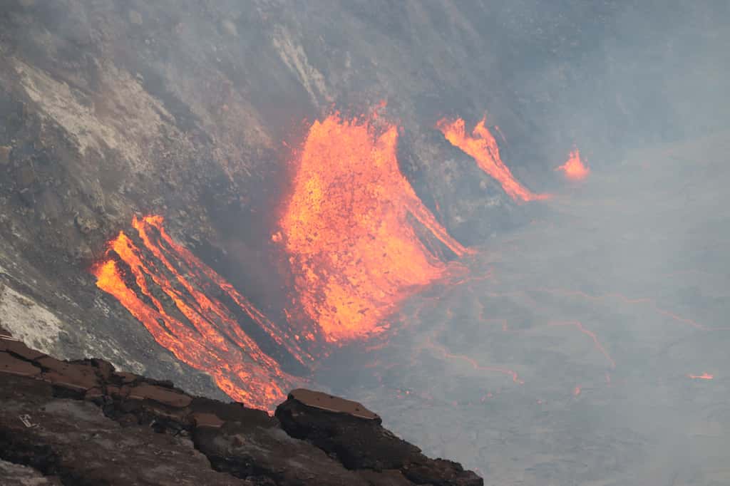 Une image au téléobjectif des fissures qui se sont ouvertes sur la paroi ouest du cratère Halema'uma'u lors de l'éruption en cours qui a commencé. La lave des multiples fissures continue d'élever lentement le niveau du nouveau lac de lave actif au sommet du Kīlauea. © USGS M. Patrick