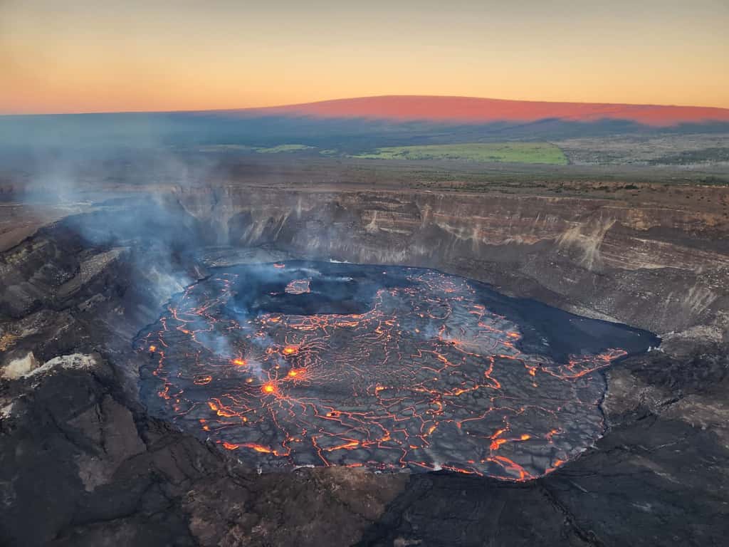Le fond du cratère Halema’uma’u au matin du 6 janvier, presque entièrement recouvert de lave ! On peut observer les évents actifs au second plan et en arrière, le bassin qui contenait le lac de lave lors de l’éruption de 2021-2022 qui s’est de nouveau rempli lors de cette éruption. © USGS