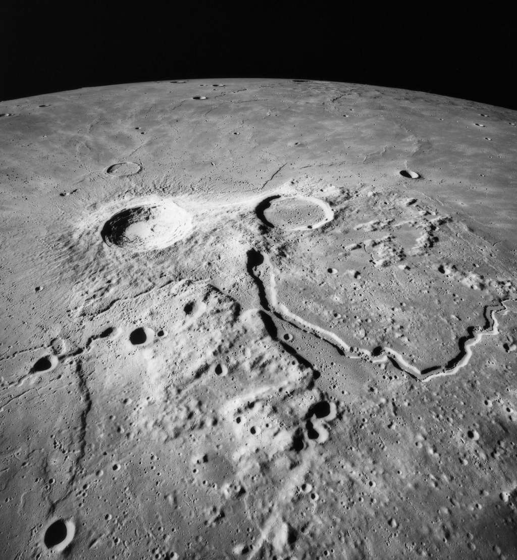 Les cratères Aristarque (à gauche) et Hérodote (à droite), vus par Apollo 15, sont connectés à droite avec la vallée de Schröter. Cette rille sinueuse de 200 km de long et jusqu'à 10 km de large qui est la plus large vallée lunaire connue correspond à une rivière de lave qui s'est solidifiée. Une rille est une longue dépression dont la surface ressemble à celle d'un canal. Le terme rille est employé internationalement en planétologie. Il est emprunté à l'allemand <em>Rille</em> (rainure, cannelure, gorge). © Nasa