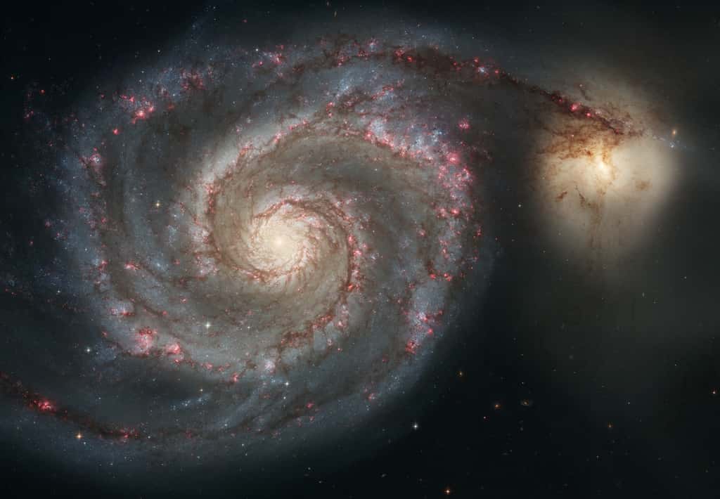 Cette photographie spectaculaire prise avec le télescope Hubble, en 2005, montre M51, aussi connue comme la galaxie du Tourbillon (<em>Whirlpool Galaxy</em> en anglais), un couple de galaxies à environ 27,4 millions d'années-lumière dans la constellation des Chiens de chasse. La galaxie spirale régulière a un diamètre estimé à 100.000 années-lumière, comme la Voie lactée, donnant une idée de ce qui se passera avec notre Galaxie quand elle entrera en collision avec une petite galaxie irrégulière, le Grand Nuage de Magellan.© Nasa