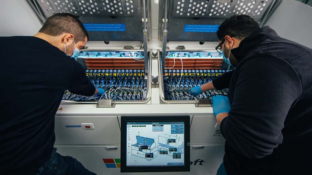 Deux ingénieurs inspectent l’intérieur du réservoir pour le refroidissement par immersion biphasée. © Gene Twedt pour Microsoft