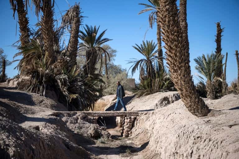 Un homme emprunte le 27 janvier 2020 un pont enjambant un ruisseau asséché dans l'oasis de Skoura, dans le sud-est du Maroc, menacée d'extinction par le dérèglement climatique. © Fadel Senna, AFP