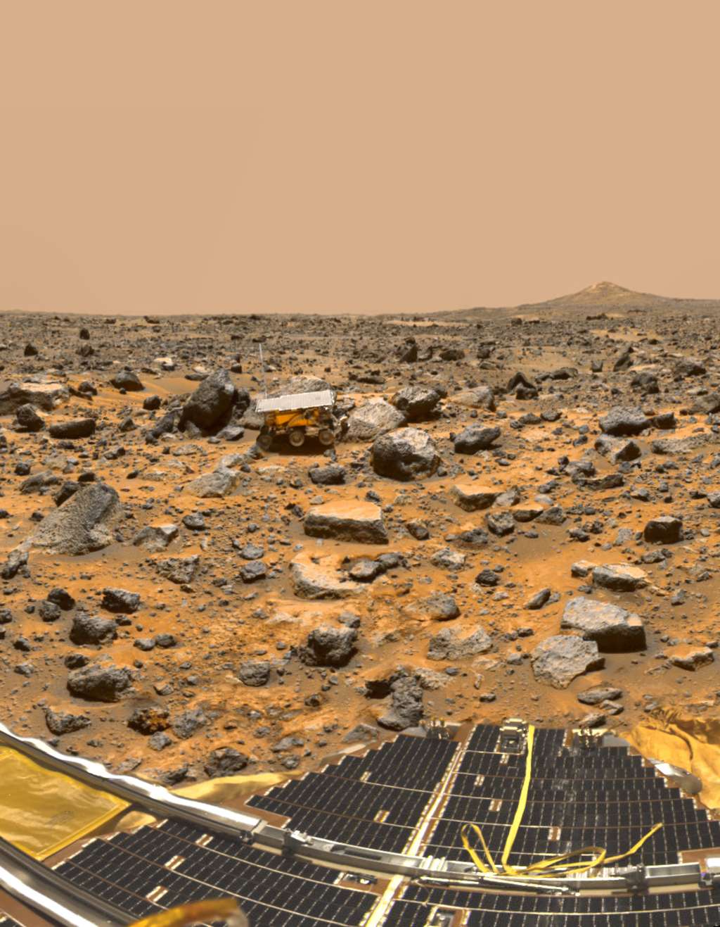 Le site où s’est posé Pathfinder (on aperçoit un de ses panneaux solaires au premier plan) en 1997. À quelques mètres de là, dans la plaine jonchée de débris, le petit rover Sojourner, premier astromobile à gambader sur Mars. © Nasa, JPL