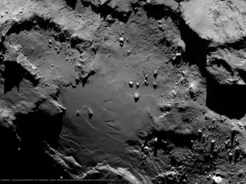 Une autre image prise par l'instrument Osiris, montrant une zone relativement lisse, bordée de reliefs escarpés. Rosetta était alors à 130 km de la comète. La résolution est de 2,4 m par pixel. © Esa/<em>Rosetta/MPS for Osiris Team</em>/UPD/LAM/IAA/SSO/INTA/UPM/DASP/IDA