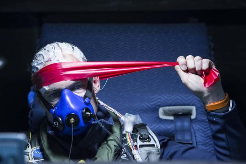 Bardé de capteurs pour suivre ses paramètres physiologiques, Bertrand Piccard, assis dans son cockpit, effectue quelques exercices physiques pour se dégourdir les muscles et les articulations. © Solar Impulse