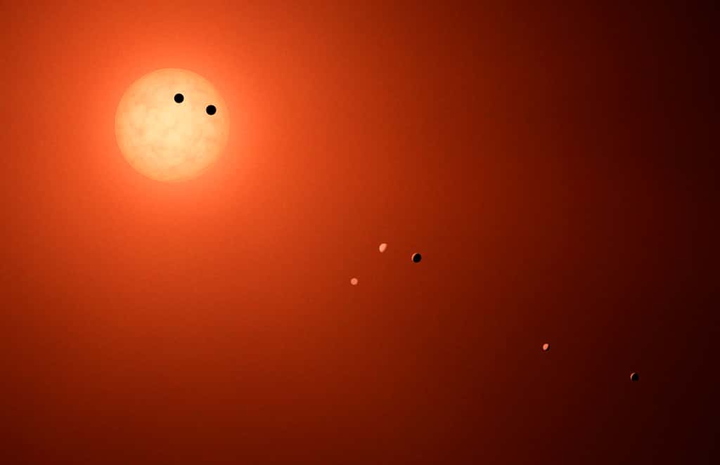 Comparaison du système planétaire de Trappist-1 (en haut) avec celui du Soleil (en bas). L’anneau en vert marque la zone habitable pour chacune des deux étoiles. Mis dans notre Système solaire, les orbites des sept planètes rocheuses tiendraient à l’intérieur de l’orbite de Mercure. © Nasa, JPL, IPAC