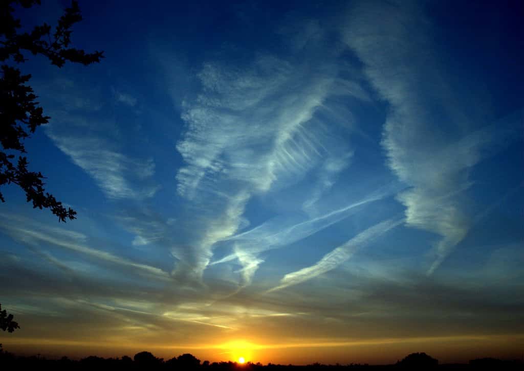 Les traînées laissées par les gaz d’échappement des avions forment des nuages qui piègent la chaleur réémise par la Terre. © Ken Douglas, Flickr